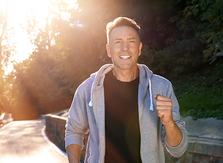 Man in gray jacket jogging outside